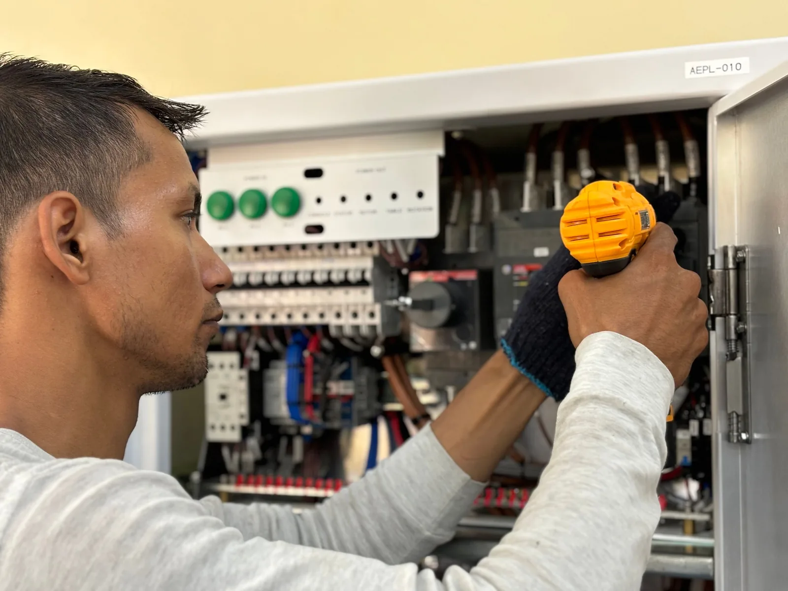 An electrician working on a commercial control panel, for subpanel installation in Windsor