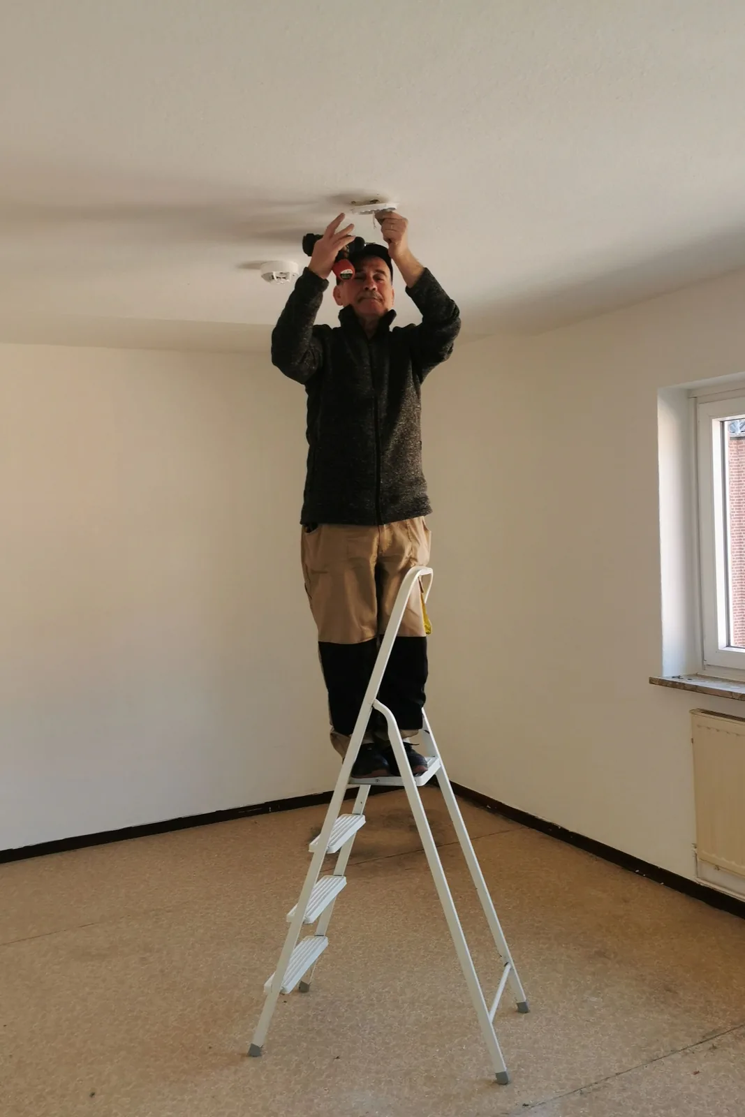 Fitting a ceiling detector from a step ladder, for ceiling fan installation in Windsor