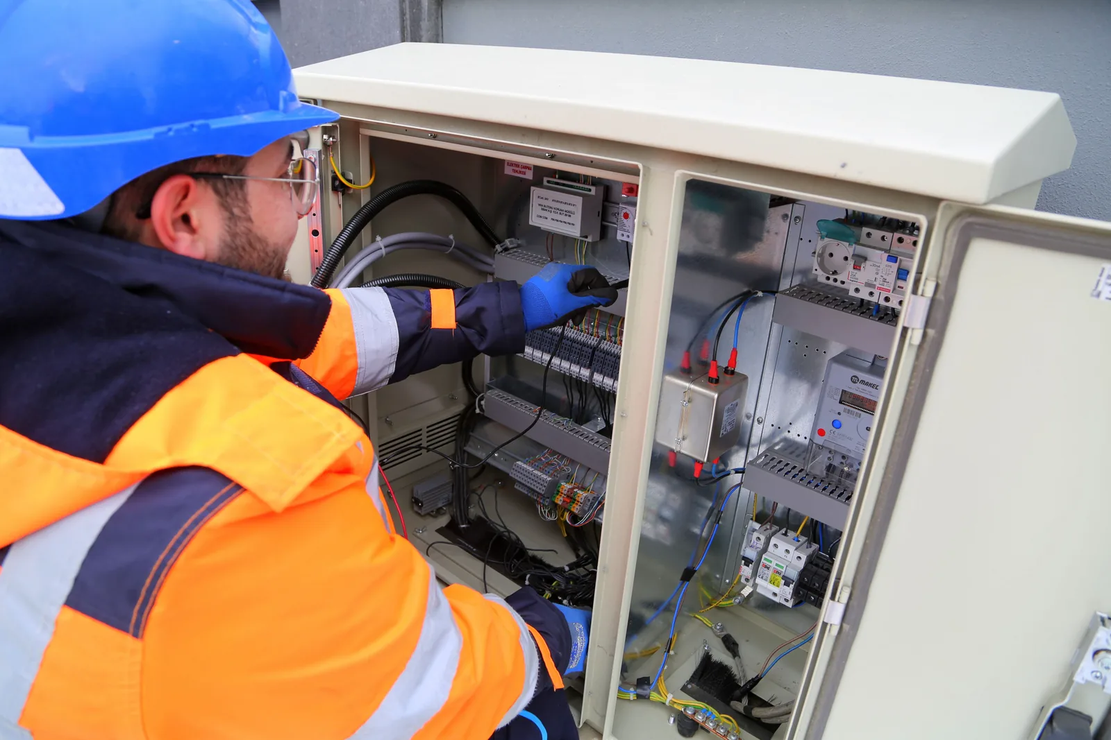 An electrician working in an outdoor service cabinet, for surge protection in Windsor